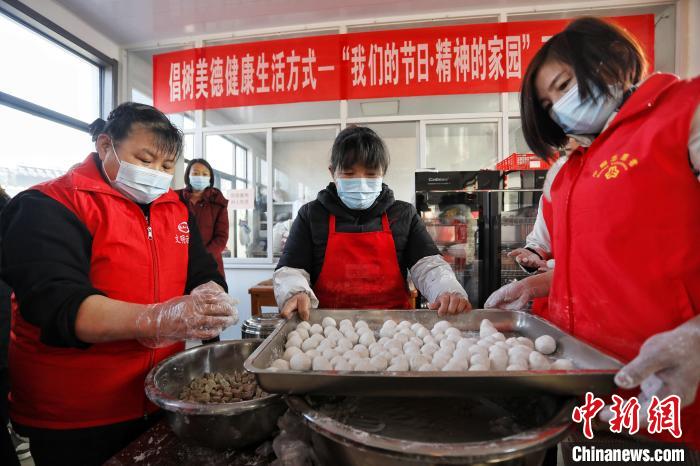 在泰安市泰山區(qū)邱家店鎮(zhèn)王林坡村的幸福食堂，眾多志愿者帶領(lǐng)村里的庫區(qū)移民包元宵。　陳陽 攝